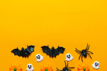 Halloween holiday concept, Spooky pumpkins , black spiders, bats and tiny ghost in orange background with copy space for text, Top flat view wallpaper