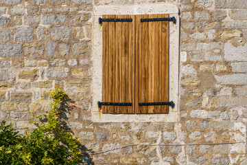 building is made of stone with wooden shutters on the windows