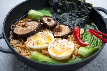 Close-up of ramen with pak-choi, shiitake, nori and egg, selective focus, studio shot