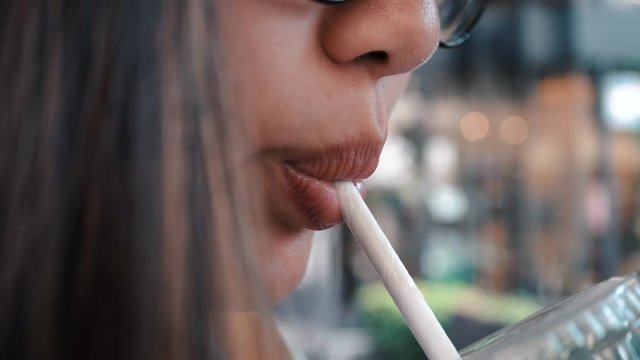 Closeup Asian Woman Drinking From Paper Straw. No plastic pollution.