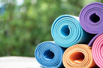 close up of colorful yoga mat on the table, sport and healthy concept - obrazy, fototapety, plakaty