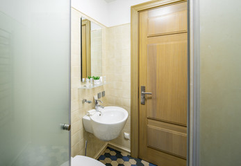 Fototapeta na wymiar Interior of bathroom in modern apartment. Shower cabin. Sink. Toilet.