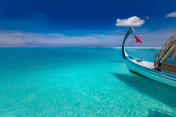 Obraz premium Inspirational Maldives beach design. Maldives traditional boat Dhoni and perfect blue sea with lagoon. Luxury tropical paradise concept