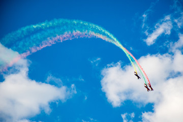 Aerobatics, air show. Aircraft team performing in the sky with old airplanes and drawing drawing Lithuanian flag, white clouds and blue sky