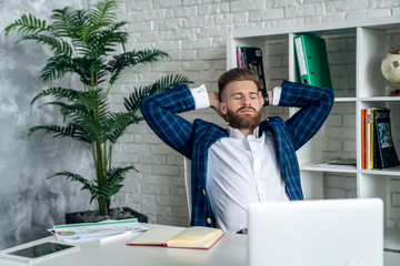 Stylish bearded man working taking a break in modern office