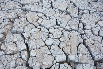 Dry soil with deep cracks. Cracked mud surface. Texture of cracks on the ground.