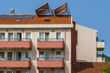 Hotel building, windows, balconies and solar panels on the roof.