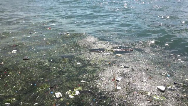 Trash and garbage floating on the surface of the water. Water pollution with dirt and plastic garbage floating on the surface of the sea 