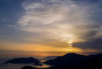 Seascape with mountain silhouettes at sunset.  Turkish Oludeniz Beach, aerial view from the mountain