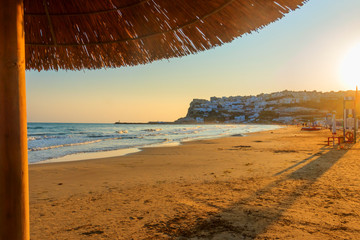 Panoramic view of the bay of Peschici at sunrise: the old town and the sandy beach, Italy (Apulia)....