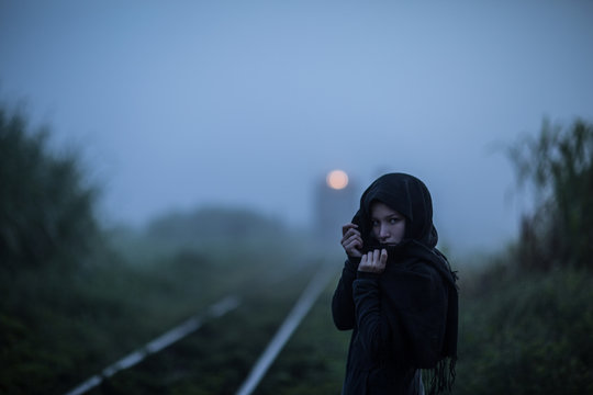woman on the train track in the mist
