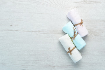Colored towels for spa treatments. On a white wooden background. Flat lay.