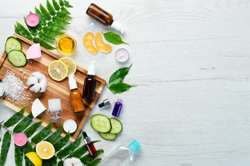 Face Care. Bottles with face cream, bottle with pipette. On a white wooden background. Flat lay.
