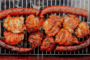Grill view with sausages. Top view of baked sausages. Spending time together with the family at the grill. Social meetings, friends. Juicy and well-grilled sausages.