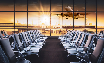 Empty airport terminal lounge with airplane on background. Modern airport waiting area with flyinf...