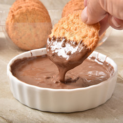 Dunking a coconut macaroon in chocolate