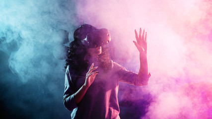 Obraz premium Virtual reality game. A girl in a VR helmet plays a game or explores the environment.