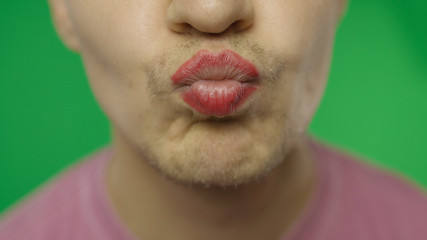 Bearded man with painted lips kiss on the camera. LGBT community. Transsexual