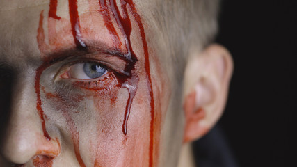Halloween man portrait. Guy with dripping blood on his face. Scary makeup