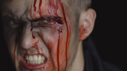 Halloween man portrait. Guy with dripping blood on his face. Scary makeup © Andrii Iemelianenko