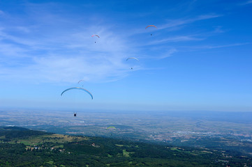Paragliders in full flight over volcanoes of Puy de Dome