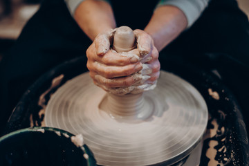 master makes a vase of clay, clay circle, close-up hands, mug of raw clay, hands made