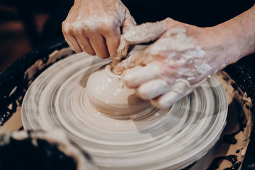 master makes a vase of clay, clay circle, close-up hands, mug of raw clay, hands made