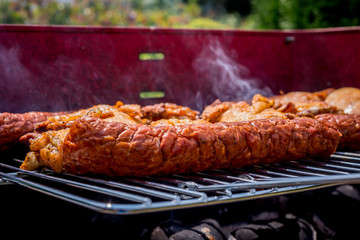Grill view with sausages. Top view of baked sausages. Spending time together with the family at the grill. Social meetings, friends. Juicy and well-grilled sausages.