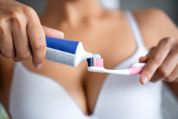Female squeezing the toothpaste from the tube