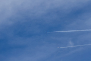 Two planes leaving wake in the blue sky