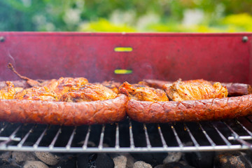 Grill view with sausages. Top view of baked sausages. Spending time together with the family at the grill. Social meetings, friends. Juicy and well-grilled sausages.