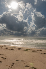 Sandstrand am Meer mit schwarzen Wolken