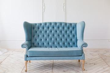 Blue soft sofa in light interior with fabric upholstery