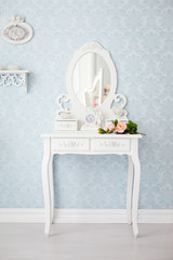 Elegant white commode (dressing table) with beautiful mirror and tea rose flower on it
