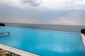 Fototapeta na wymiar Infinity pool with crystal blue water view to sea ocean