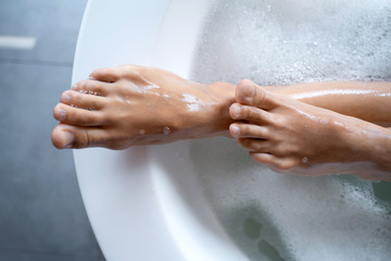 Caucasian female feet protruding from a bath