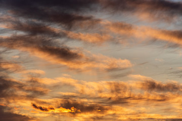 Sunset with cloudy sky, cirrus clouds, blues, oranges and yellows, nature background