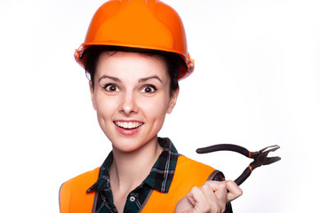 beautiful young girl worker in a helmet holds a screwdriver in his hand