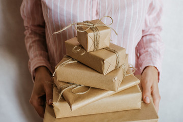 Woman holding many gift boxes in hand. Holiday present. Boxes with surprise. Happy celebration...