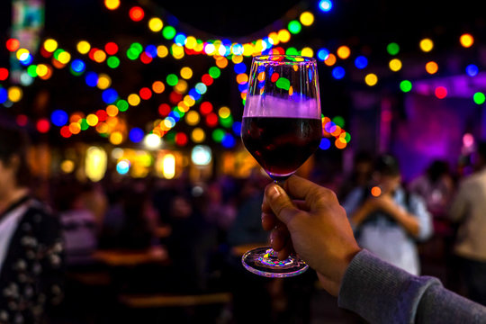 summer festival event with light bokeh and a glass of red wine wine festival with colorful lights
