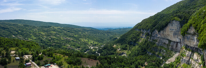 Fototapeta premium The Kinchkha waterfall in the canyon of the river Okatse. Rest in Georgia. High waterfall in the Imereti region. Rocky ledges of the mountain with green trees