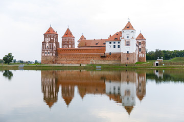 Fototapeta na wymiar Mirsky Castle and its reflection in the lake in summer