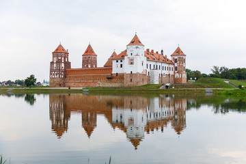 Obraz premium Mirsky Castle and its reflection in the lake in summer