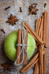 Top view: an apple, cinnamon sticks, star-anise, cloves and snow