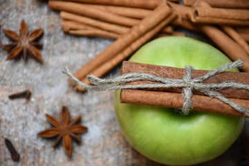 Top view: an apple, cinnamon sticks, star-anise, cloves and snow