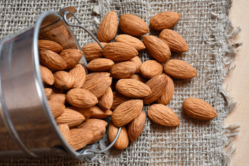 Top view: almonds spilling out of a metallic bucket