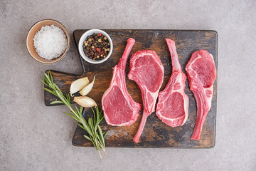 Raw lamb chops on stone background