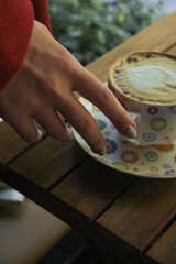 cup of coffee in hand on wood background