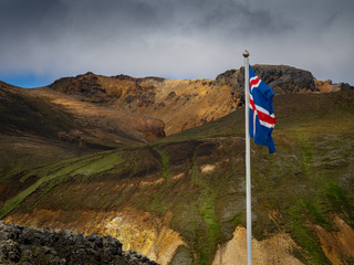 Icelandic flag against the backdrop of the Landmannalaugar mountains