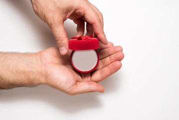 Empty open red jewelry box in a male hands. Present. White background. Top view